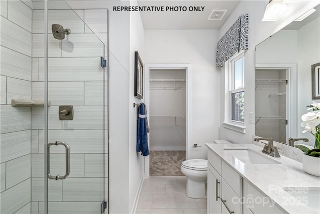 bathroom with vanity, a shower with door, tile patterned floors, and toilet