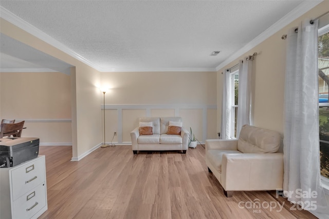 sitting room featuring crown molding, a textured ceiling, and light hardwood / wood-style floors