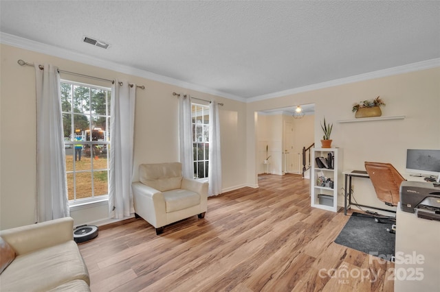 office space with ornamental molding, a textured ceiling, and light hardwood / wood-style flooring