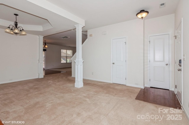 interior space with light colored carpet, visible vents, baseboards, decorative columns, and crown molding