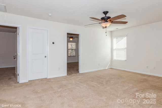 spare room with a ceiling fan, light carpet, visible vents, and baseboards