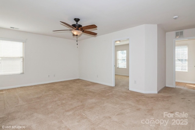 empty room featuring visible vents, ceiling fan, light carpet, and baseboards