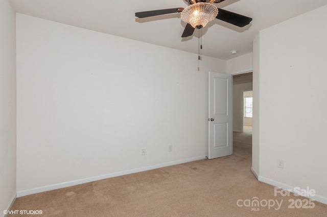 spare room with baseboards, a ceiling fan, and light colored carpet