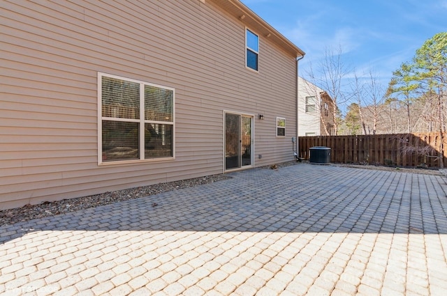 rear view of house with a patio, central AC unit, and fence