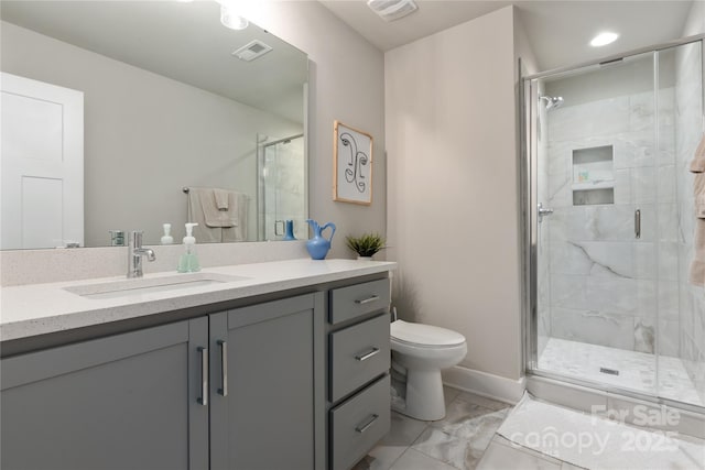 bathroom with a shower with door, vanity, and toilet