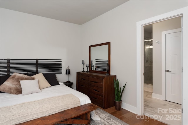 bedroom featuring ensuite bathroom and light wood-type flooring