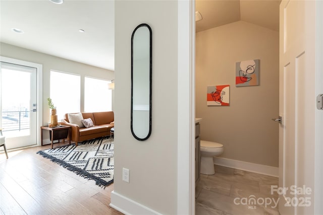 bathroom featuring hardwood / wood-style flooring, vaulted ceiling, and toilet