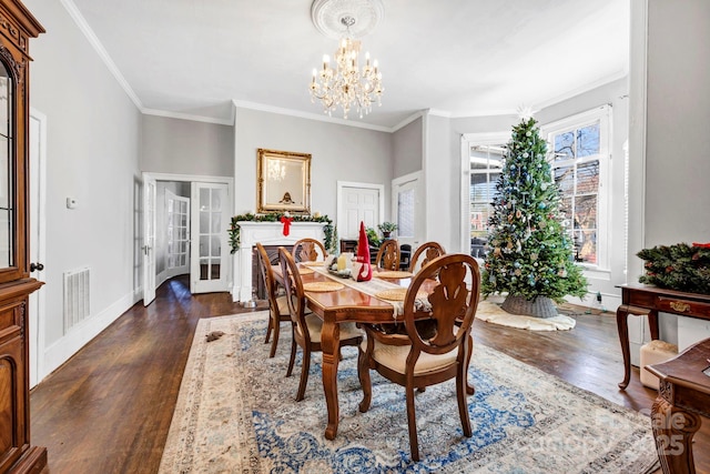 dining area featuring ornamental molding, dark hardwood / wood-style floors, a chandelier, and french doors