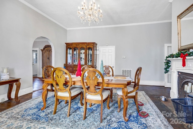 dining space with crown molding, a chandelier, and dark hardwood / wood-style flooring