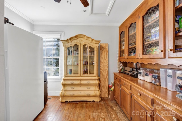 dining space with crown molding, ceiling fan, and hardwood / wood-style flooring