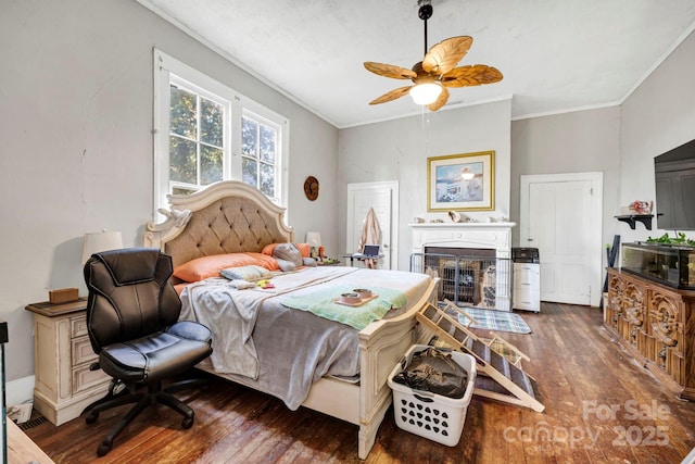 bedroom with ornamental molding, dark wood-type flooring, and ceiling fan