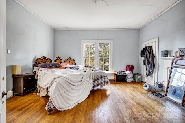 bedroom featuring crown molding and light hardwood / wood-style flooring