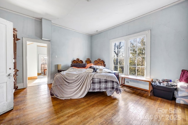 bedroom with wood-type flooring and crown molding