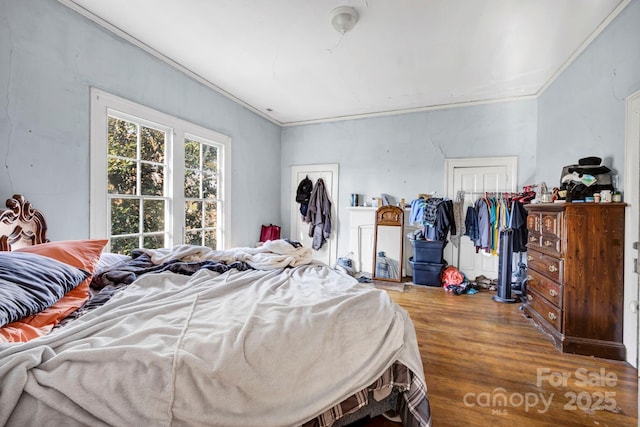 bedroom featuring ornamental molding, hardwood / wood-style floors, and a closet