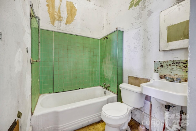 full bathroom with sink, tiled shower / bath combo, and toilet