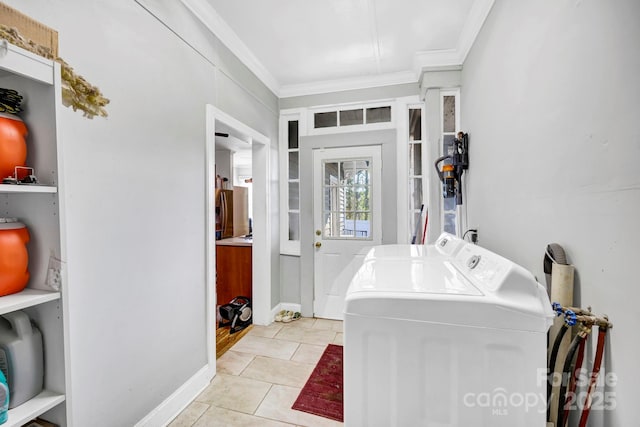 washroom with ornamental molding, washer and dryer, and light tile patterned floors