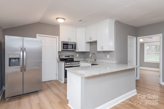 kitchen with visible vents, appliances with stainless steel finishes, white cabinetry, light stone countertops, and a peninsula