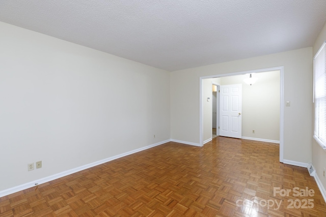 spare room featuring parquet flooring and a textured ceiling