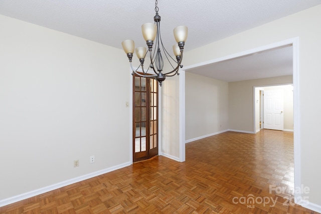 unfurnished dining area featuring parquet floors, a notable chandelier, and a textured ceiling