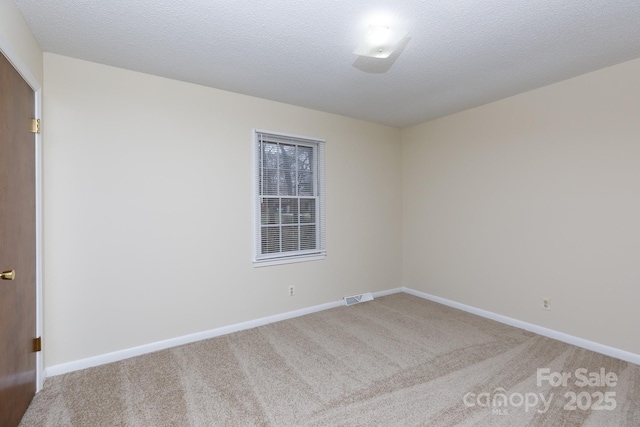 carpeted spare room with a textured ceiling