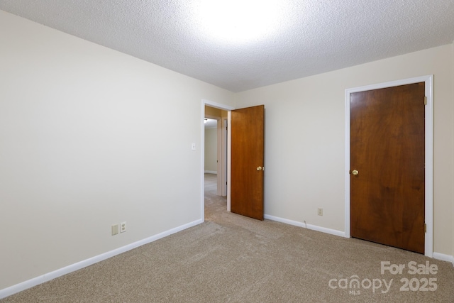 unfurnished bedroom with light carpet and a textured ceiling