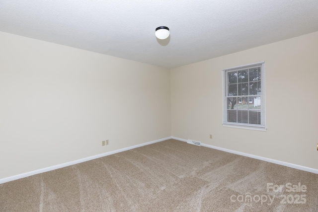 carpeted empty room with a textured ceiling