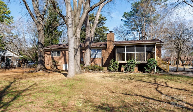 back of property featuring a yard and a sunroom