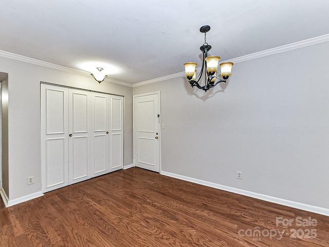 unfurnished dining area with ornamental molding, dark hardwood / wood-style flooring, and a notable chandelier