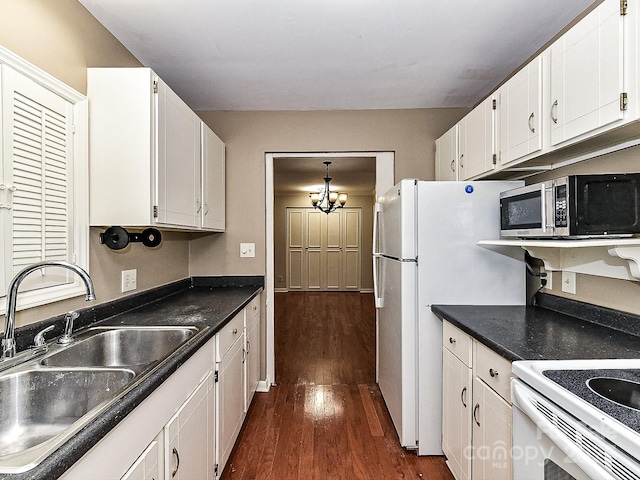 kitchen with dark wood-type flooring, sink, white cabinetry, an inviting chandelier, and white fridge