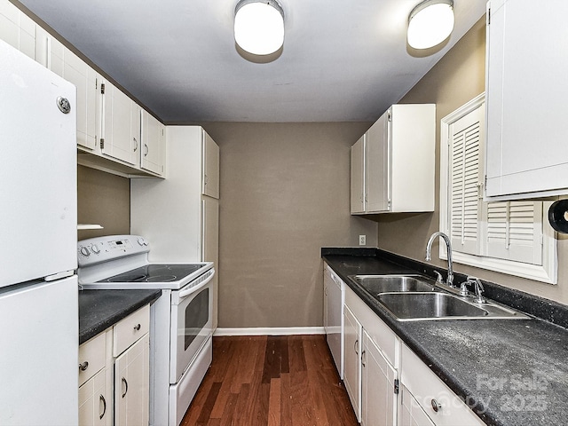 kitchen with sink, white appliances, dark wood-type flooring, and white cabinets