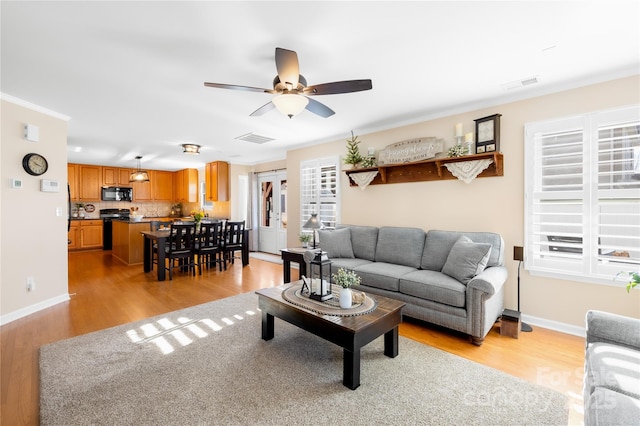 living room featuring ceiling fan, light hardwood / wood-style flooring, and crown molding