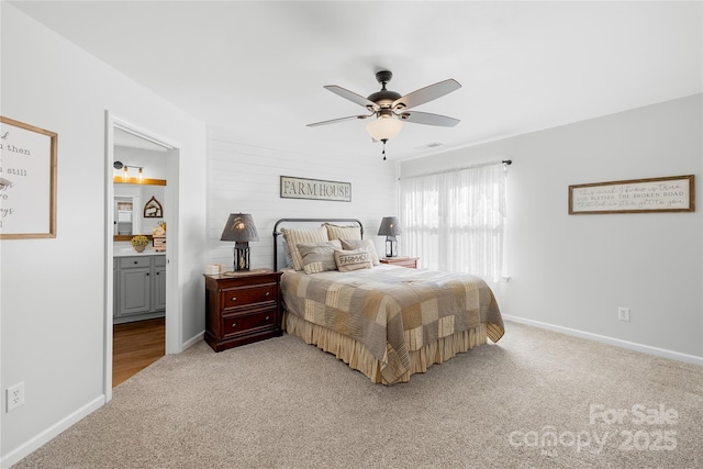 carpeted bedroom with ensuite bathroom and ceiling fan