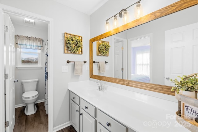 bathroom featuring wood-type flooring, vanity, and toilet