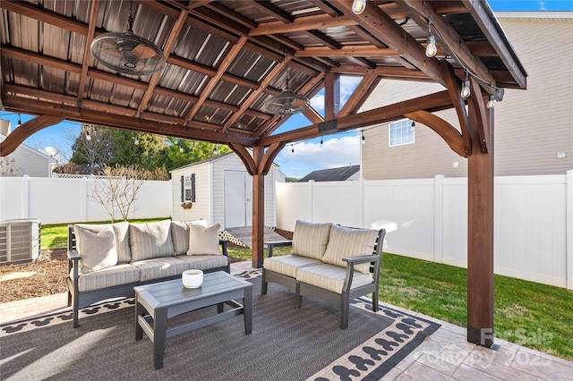 view of patio / terrace featuring central air condition unit, an outdoor hangout area, a storage unit, a gazebo, and ceiling fan