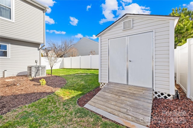 view of outbuilding featuring cooling unit and a lawn