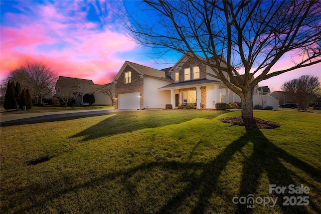 view of front of property with a garage and a yard