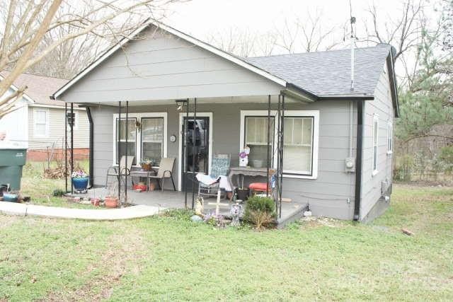 exterior space with a patio, covered porch, and a front yard