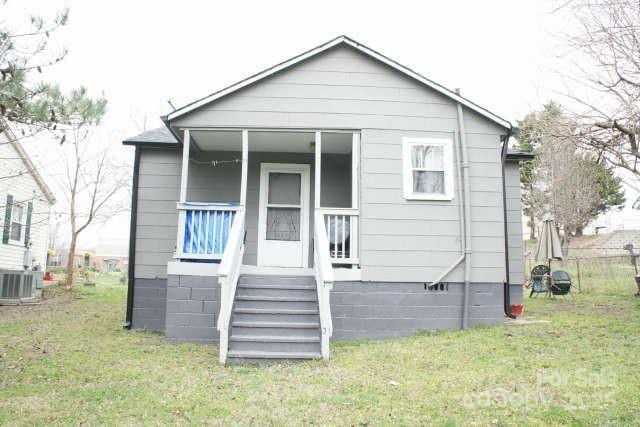 back of property featuring a yard and central air condition unit