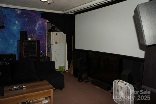 carpeted cinema room featuring a textured ceiling