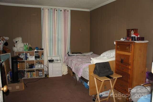 carpeted bedroom with ornamental molding