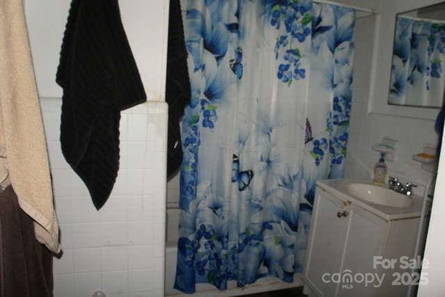 bathroom with vanity and shower / bath combo with shower curtain