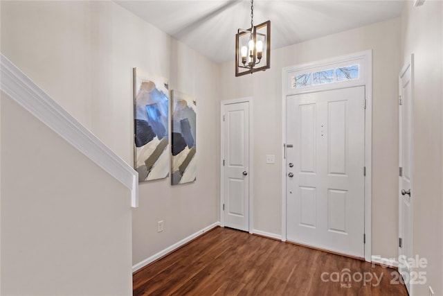 entryway featuring baseboards, dark wood finished floors, and a chandelier