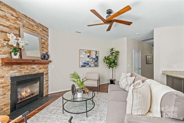 living area with dark wood-type flooring, visible vents, a fireplace, and baseboards