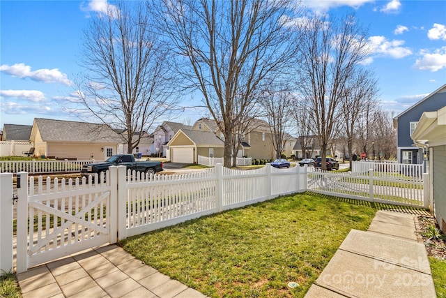 view of yard with a fenced front yard, a residential view, and a gate