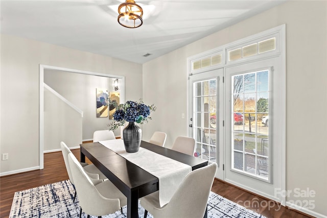 dining space featuring baseboards and dark wood finished floors