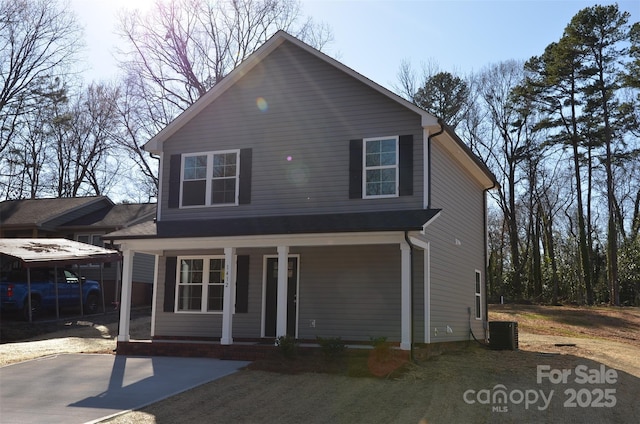 view of front of house featuring a porch, a carport, and central air condition unit