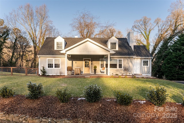 cape cod-style house featuring a front yard and covered porch