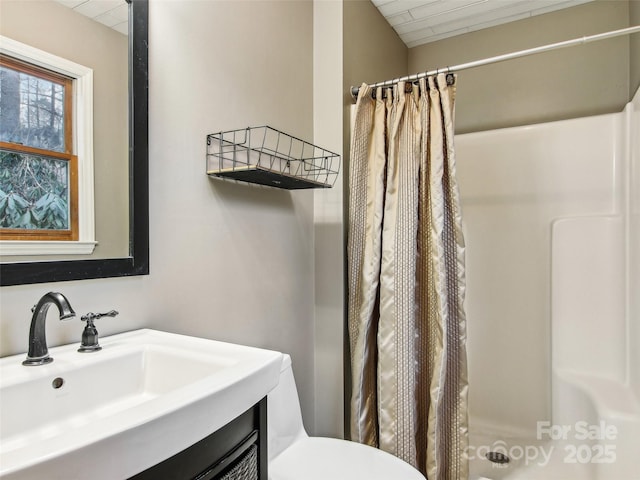 bathroom with sink, curtained shower, and toilet