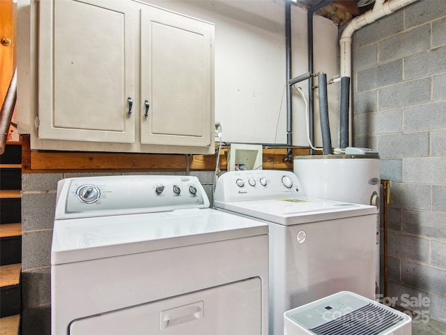 clothes washing area featuring cabinets and washer and dryer