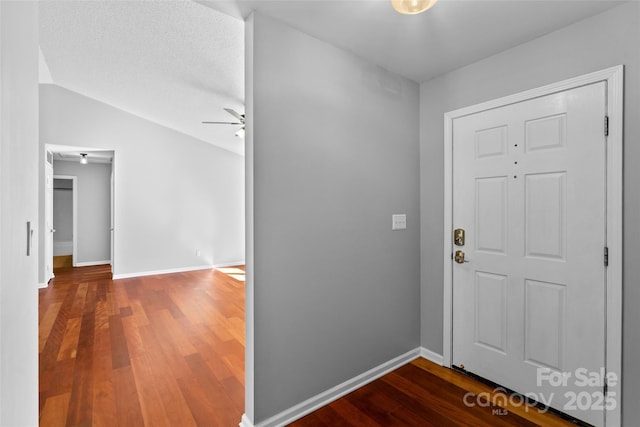 entrance foyer with baseboards, lofted ceiling, a ceiling fan, and wood finished floors